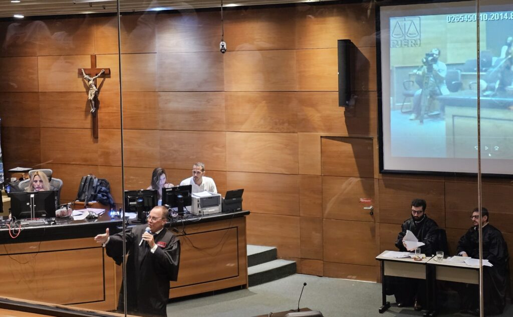 Advogado do PM, Alessandro Marcelino de Souza, no momento em que lança a hipótese de culpa consciente acatada pela juíza Tula, a fundo. 